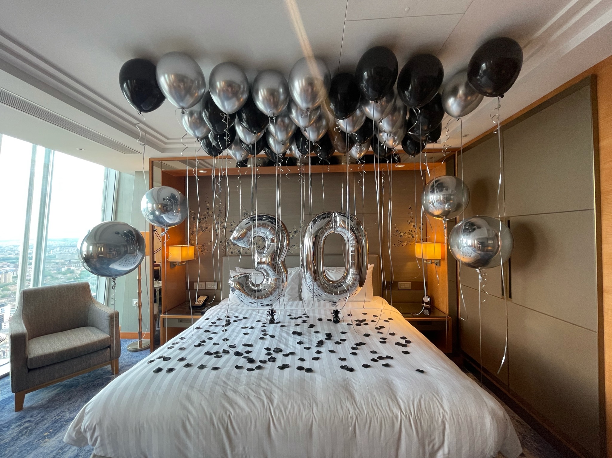 Hotel room decorated with number 30 balloons